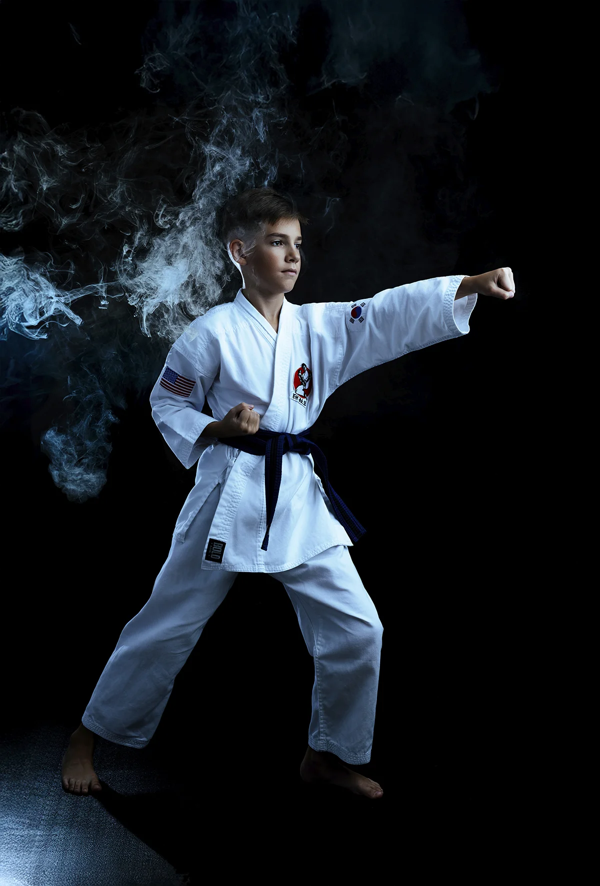 Karate athlete in punch stance with dramatic smoke