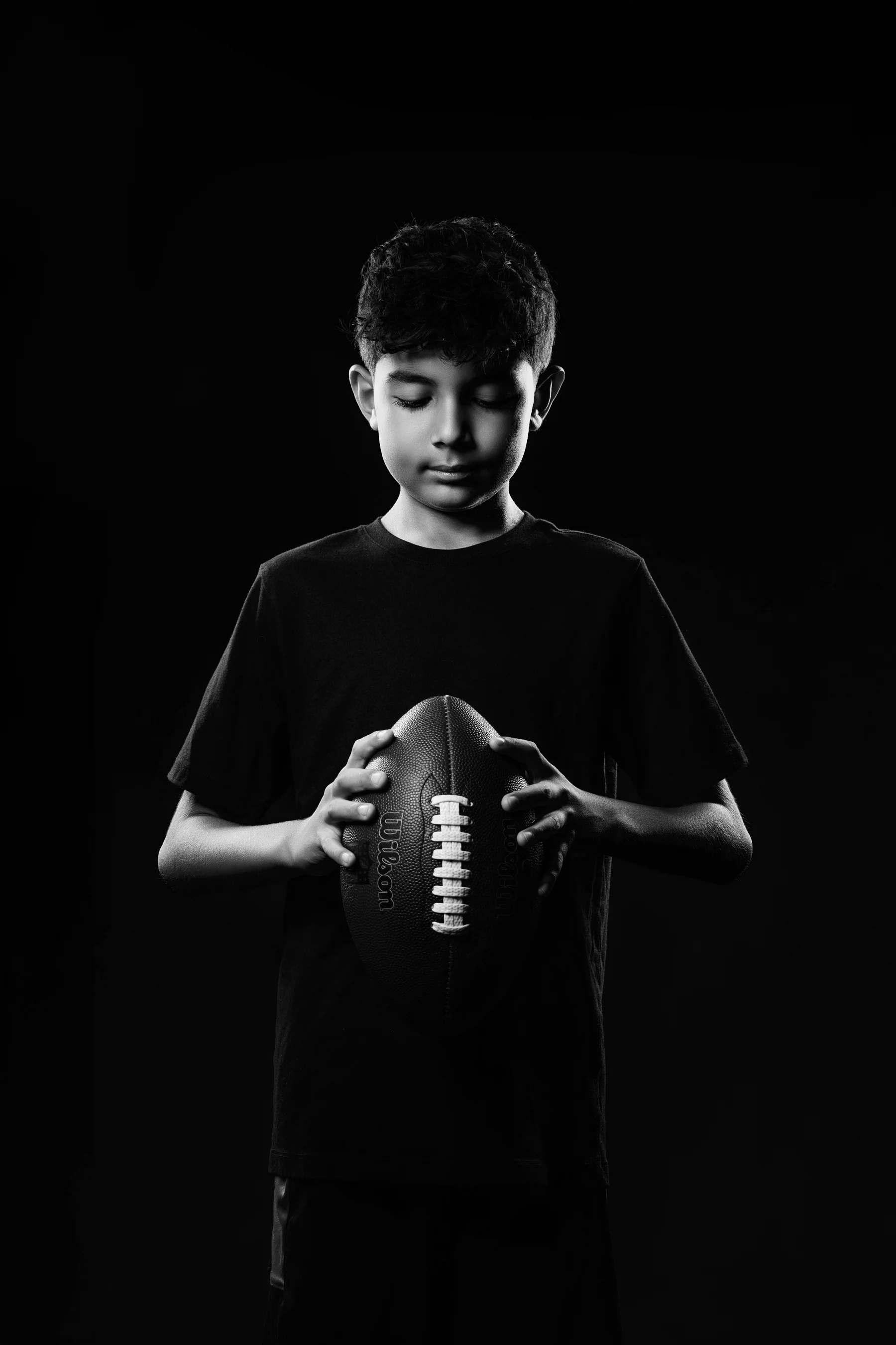 Dramatic black and white football portrait on dark background