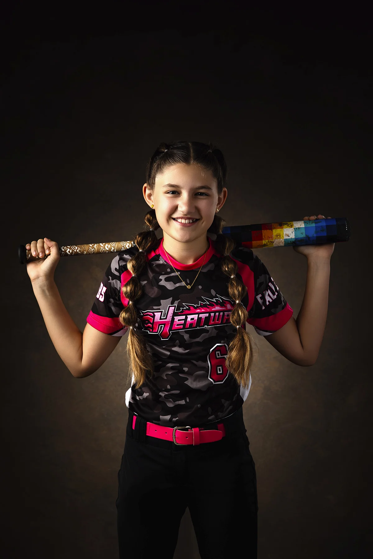 Softball girl posing with bat over shoulder