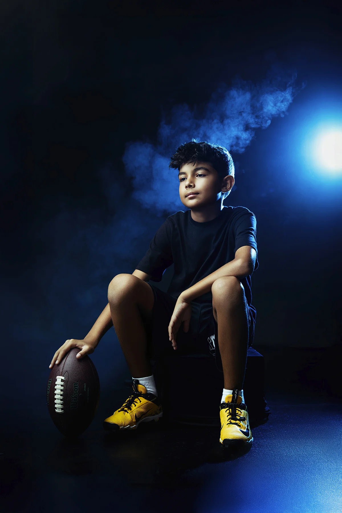 Football player seated with blue smoke background