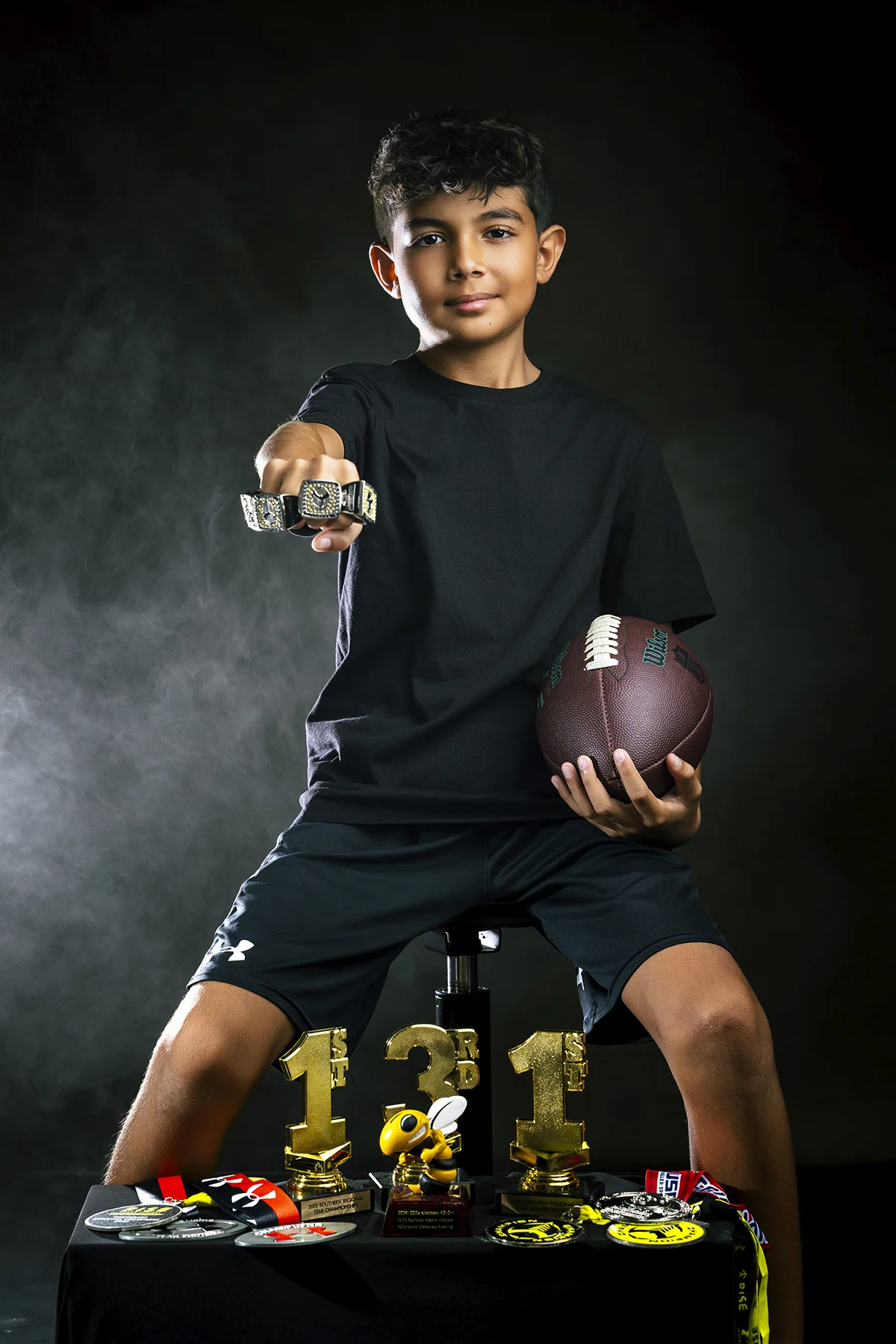 Softball girl showing championship rings with teal smoke