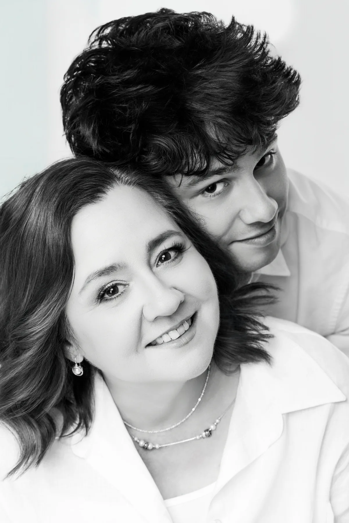 Black and white portrait of a senior with his mother, heads together and smiling