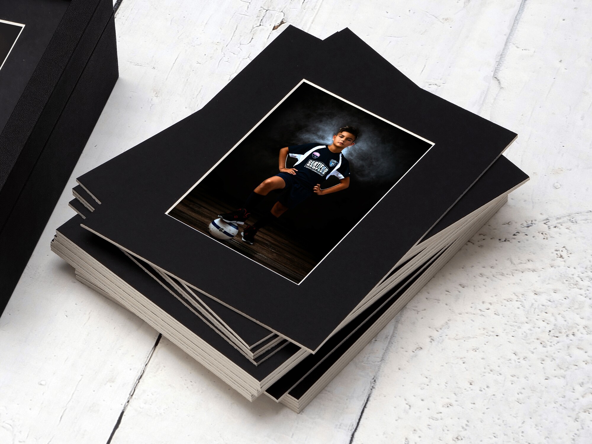 Stack of matted fine art prints from kids sports portrait session