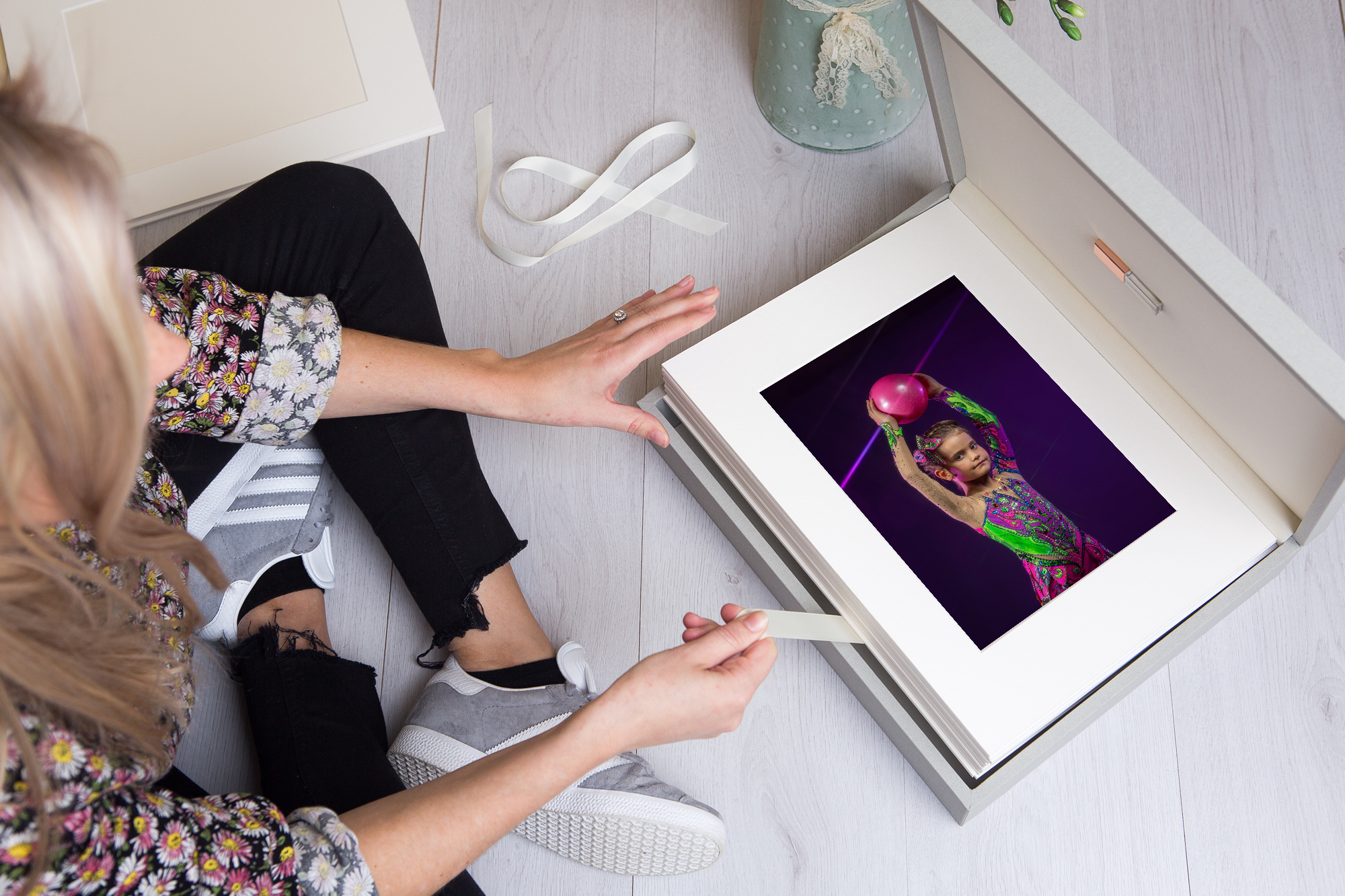 Mother opening portrait box album with gymnast sports photo